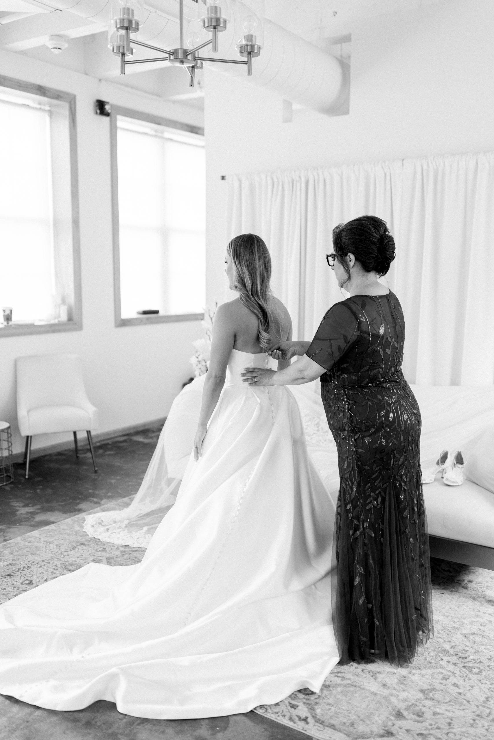 Mom helping Bride get into gown